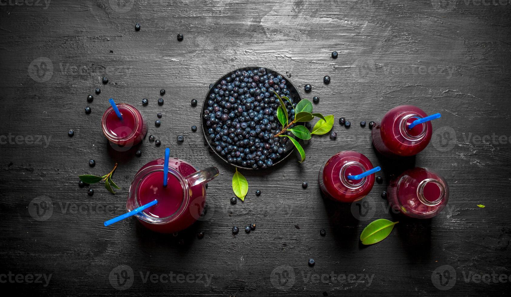 Blueberries and blueberry juice. On black wooden background. photo