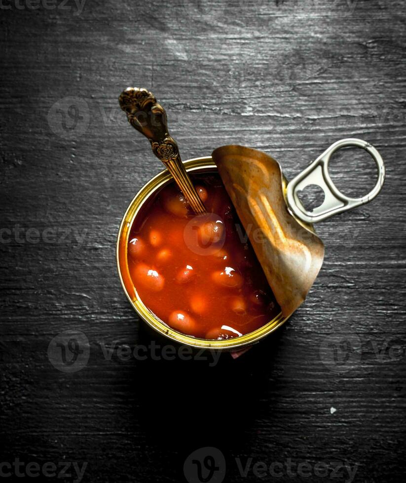 Red tinned beans. On black wooden background. photo
