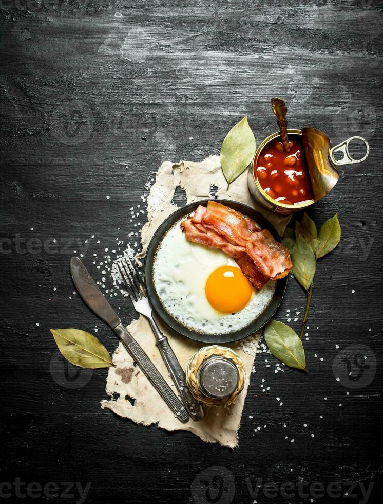 Breakfast in the morning. Beans with fried egg and bacon. photo