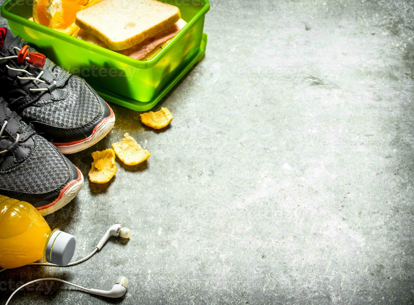 Sandwiches, orange juice and fruit. On the stone table. photo