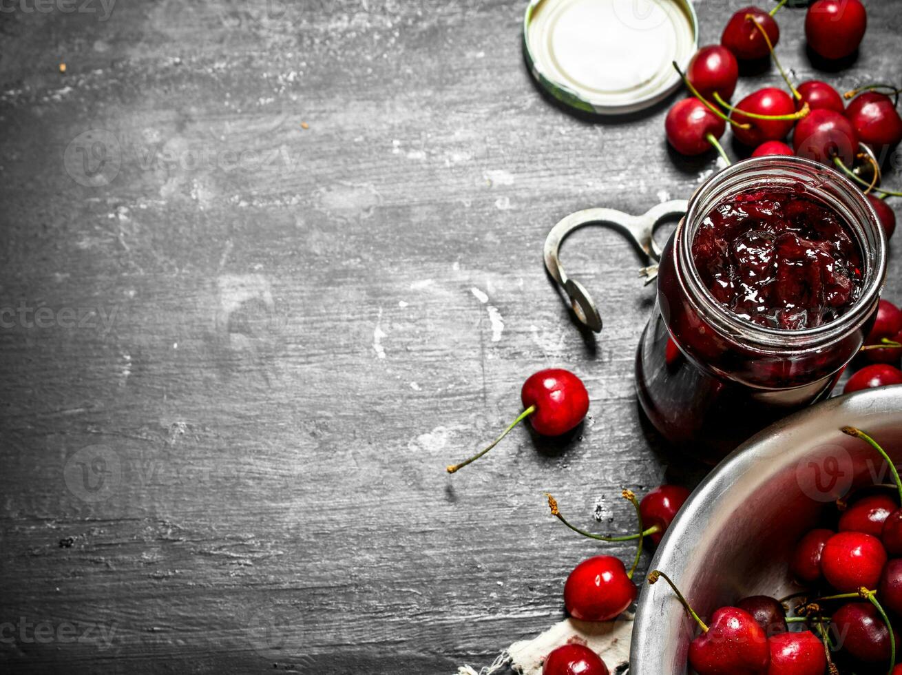 Cherry jam and metal tool for cherries. photo