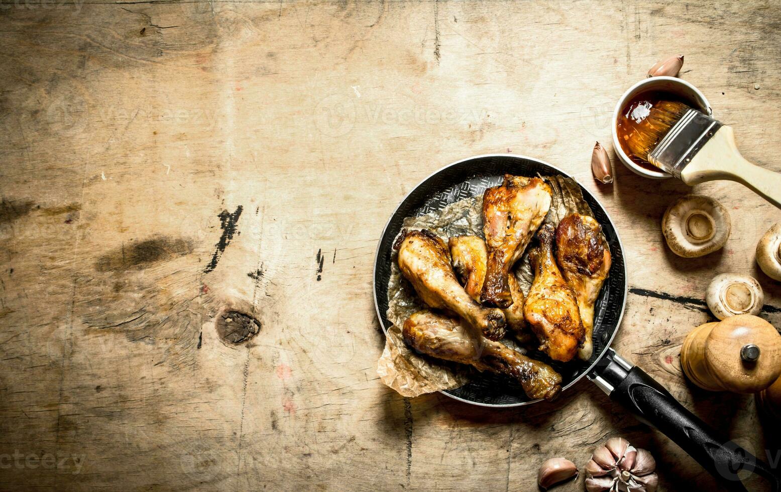 Fried chicken legs in pan with tomato sauce photo