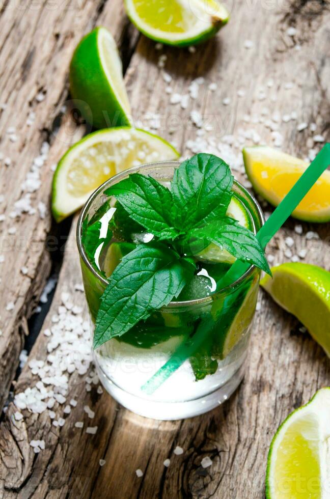 Freshly made mojito with mint and lime, sugar and rum. On a wooden table. photo