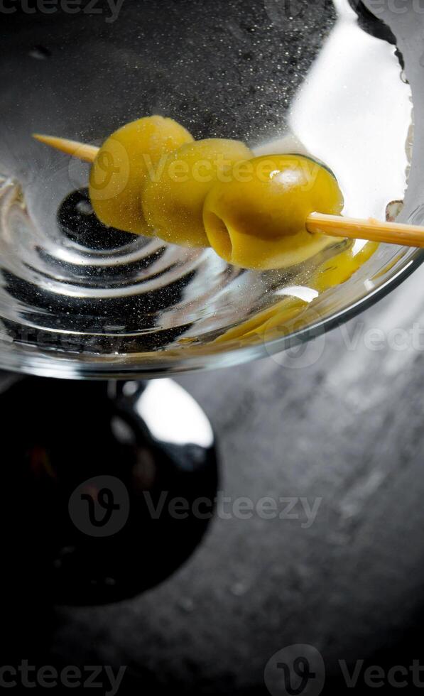 Martini with olives on a black table. Free space for text. photo