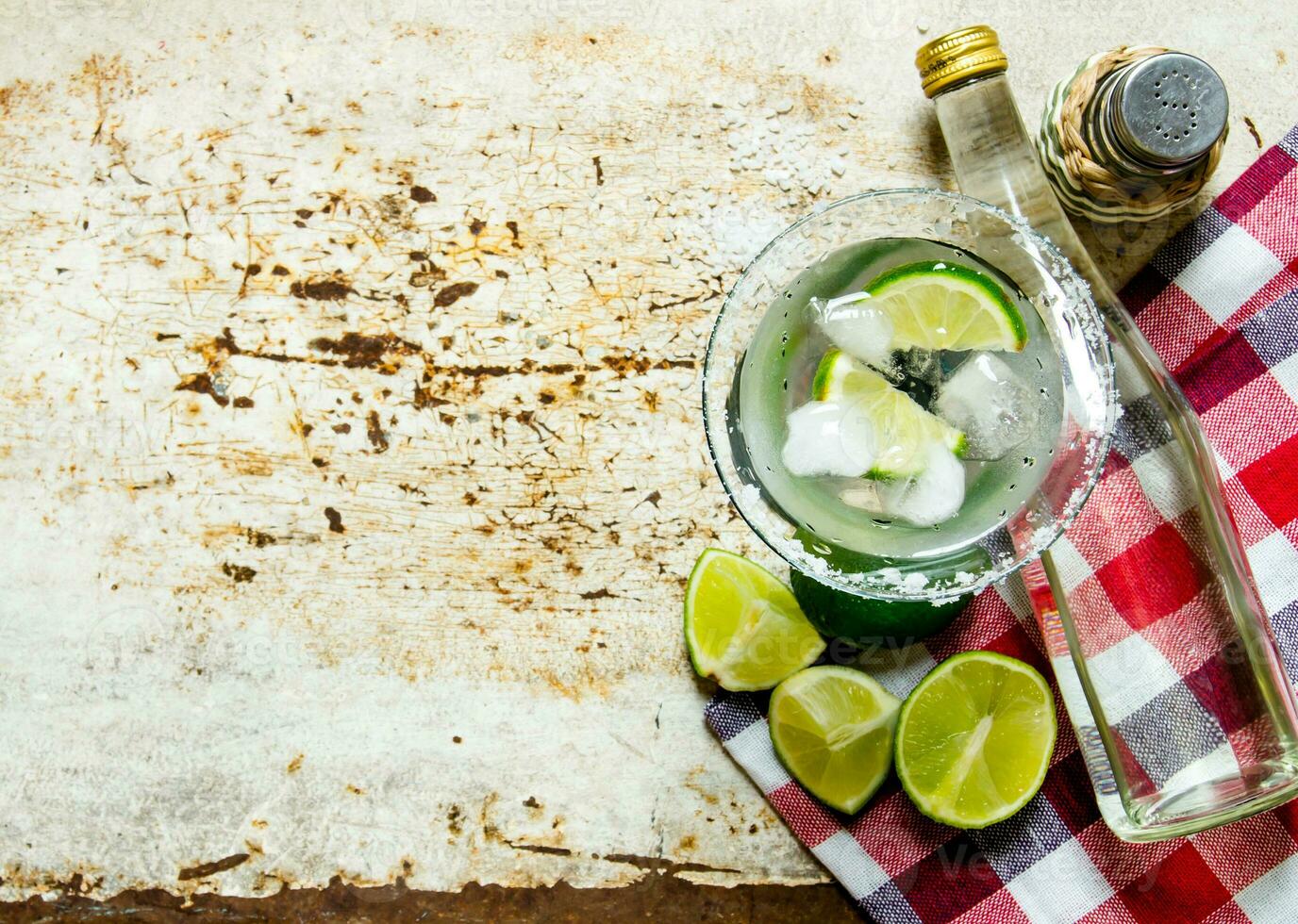 Ingredients cocktail - limes, ice , tequila, salt and liqueur on the old background . Free space for text. photo