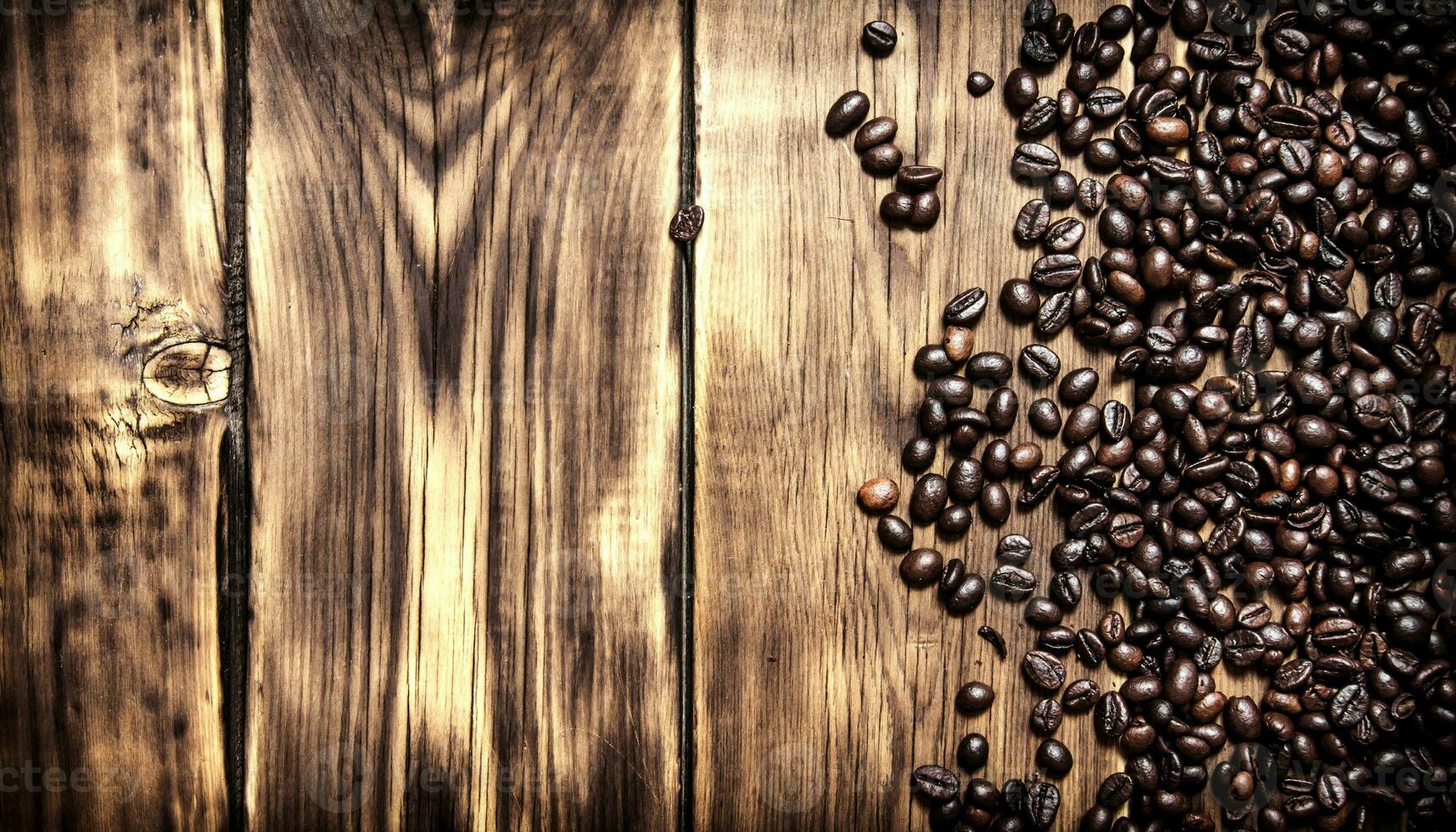 Fresh coffee beans. On wooden background. photo