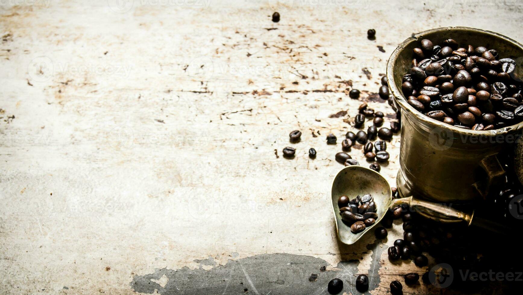 Fresh roasted coffee in old mortar. On rustic background. photo