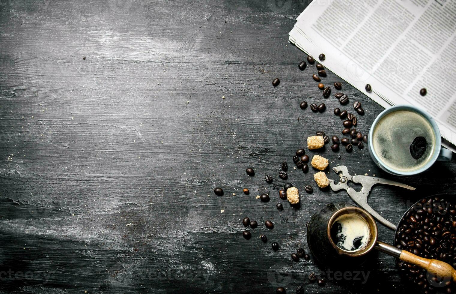 Coffee pot and a newspaper with roasted coffee beans around. photo