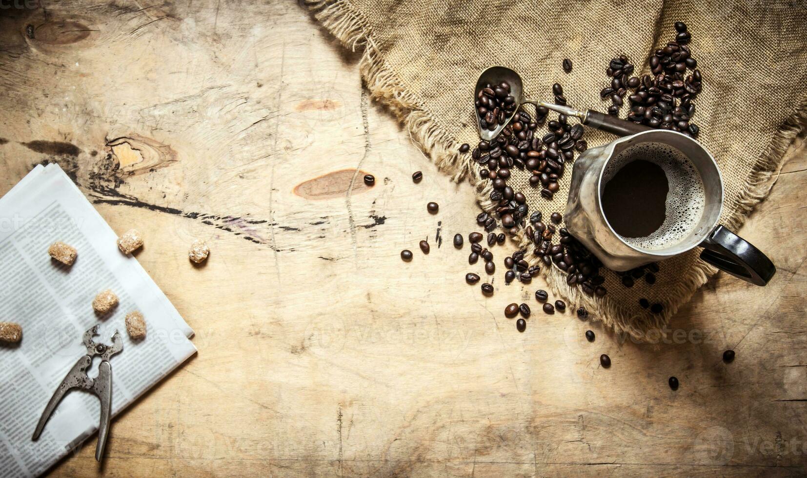 Fresh coffee in the jug and newspaper. photo