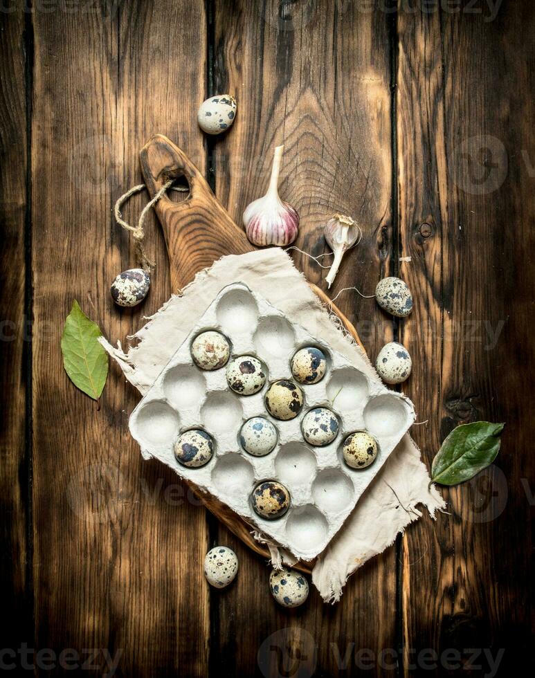 Quail eggs in a box with Laurel leaves. photo