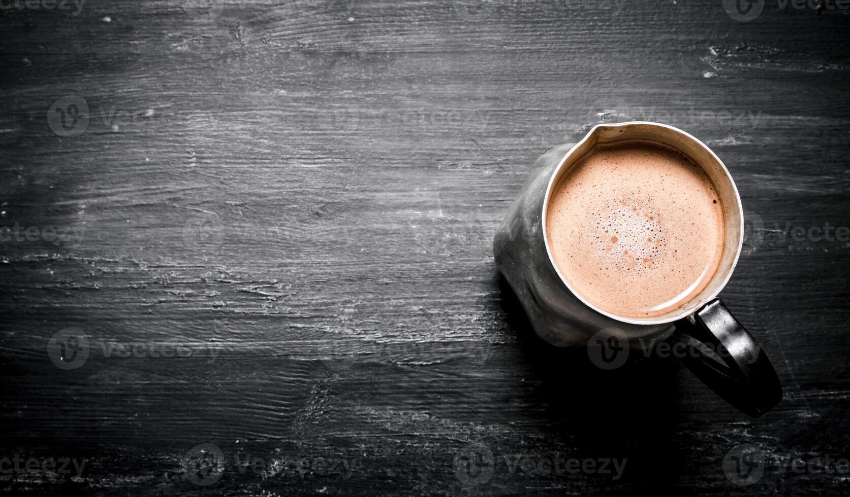 pitcher of hot chocolate. On black rustic background. photo