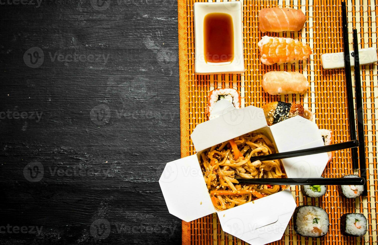 Wheat noodles with vegetables and sushi photo