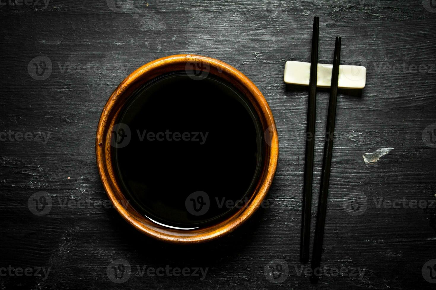 Soy sauce in a bowl and chopsticks. photo