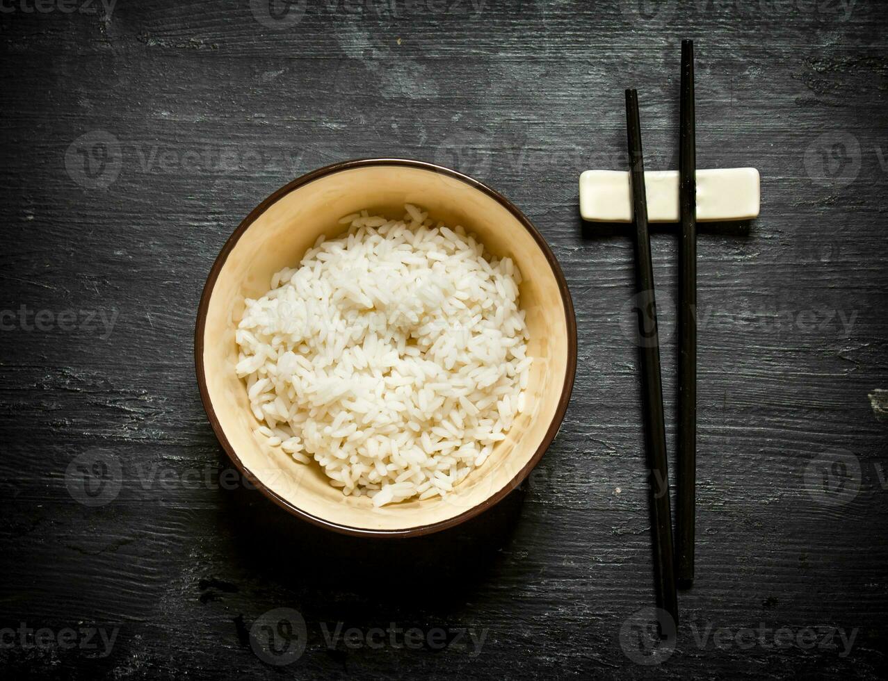 Boiled rice with chopsticks. photo