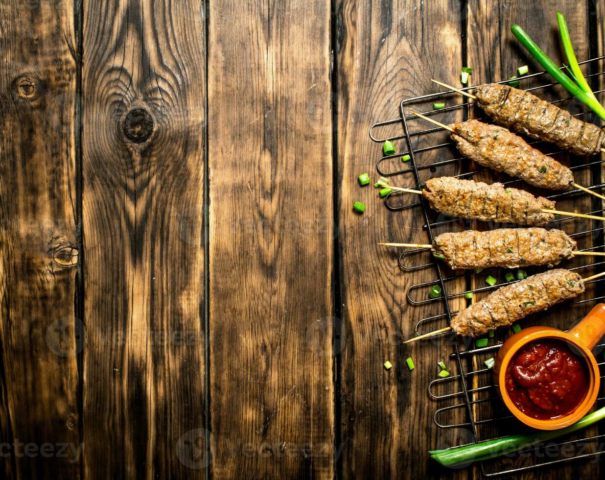 Kebab with tomato sauce and green onions. photo