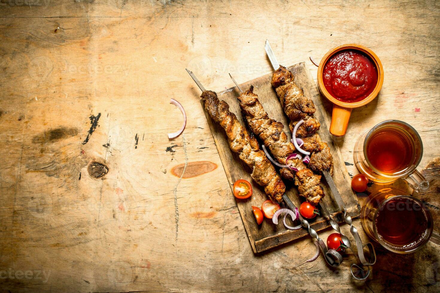 Beer with pork Shish kebab and tomatoes. photo