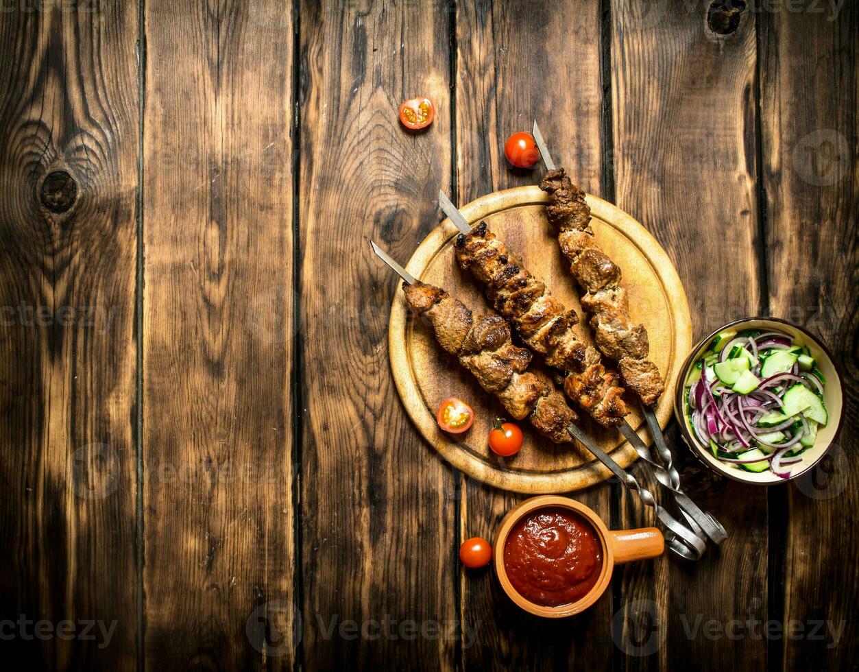 Kebab with fresh salad of cucumbers and onions. photo