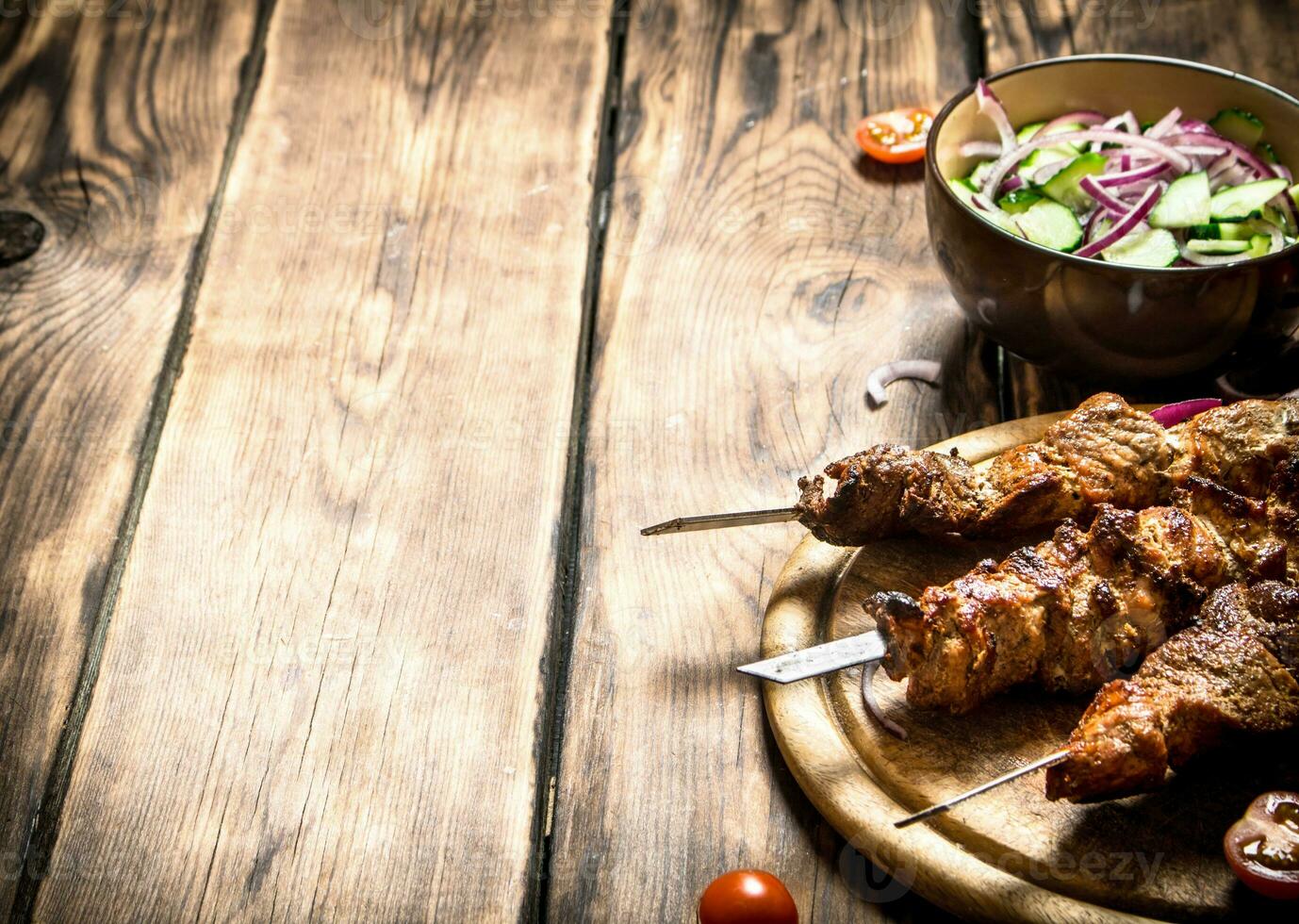 Kebab with fresh salad of cucumbers and onions. photo