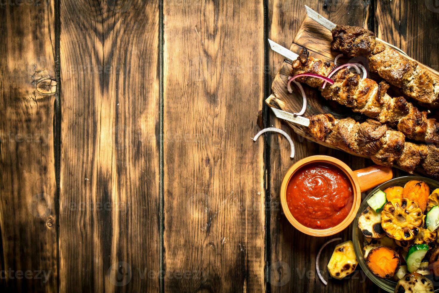 Kebab with tomato sauce and roasted vegetables. photo