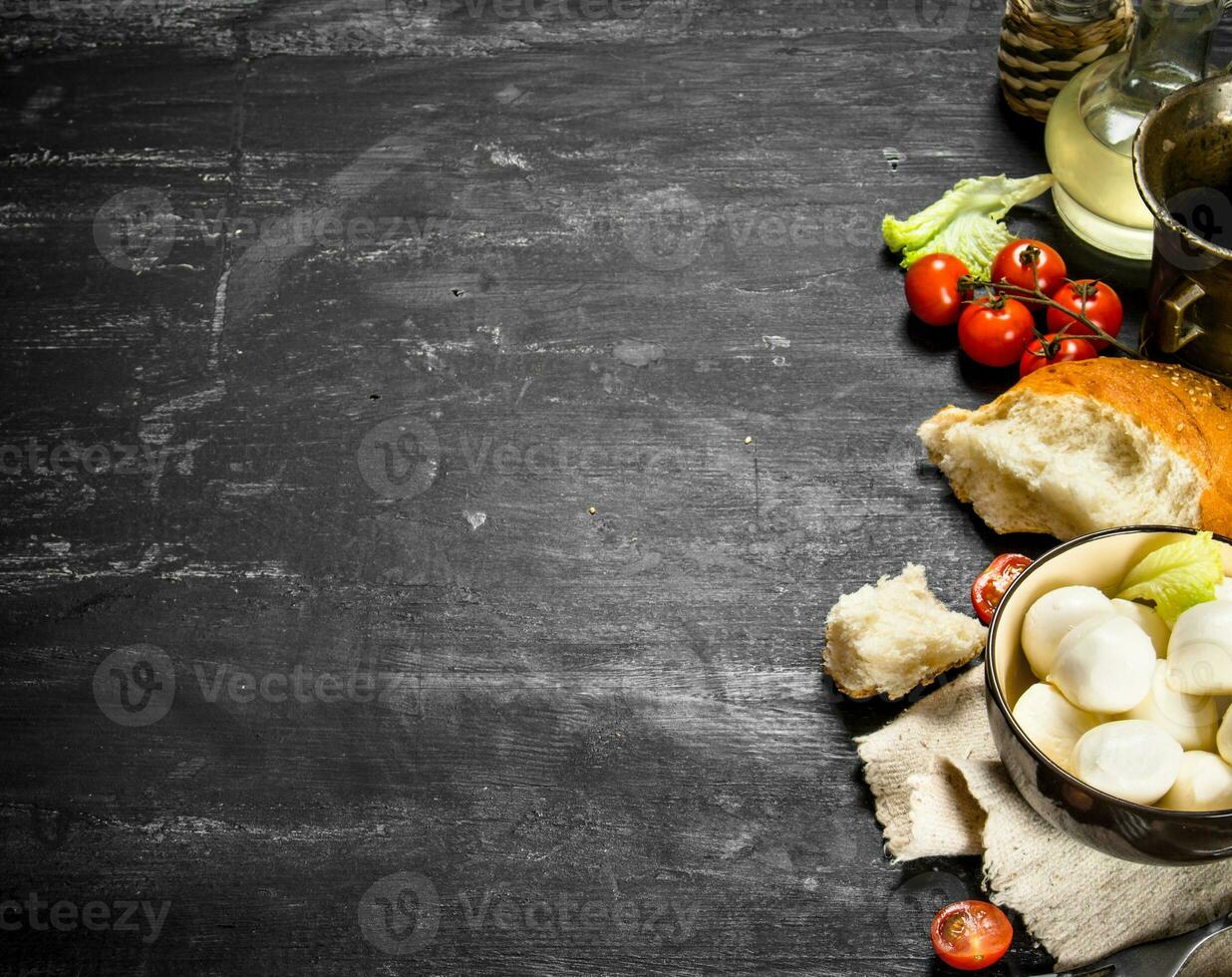 Mozzarella with fresh bread, tomatoes and greens. photo