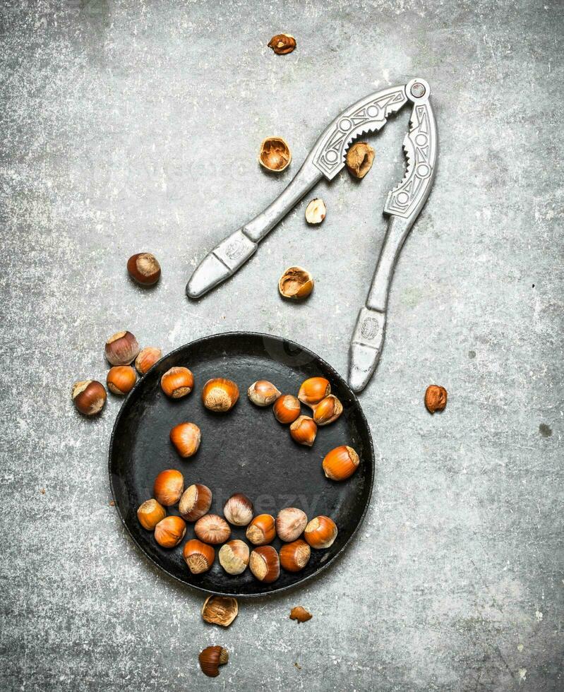 Hazelnuts and a Nutcracker in the old pan. photo