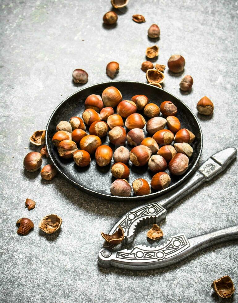 Hazelnuts and a Nutcracker in the old pan. photo