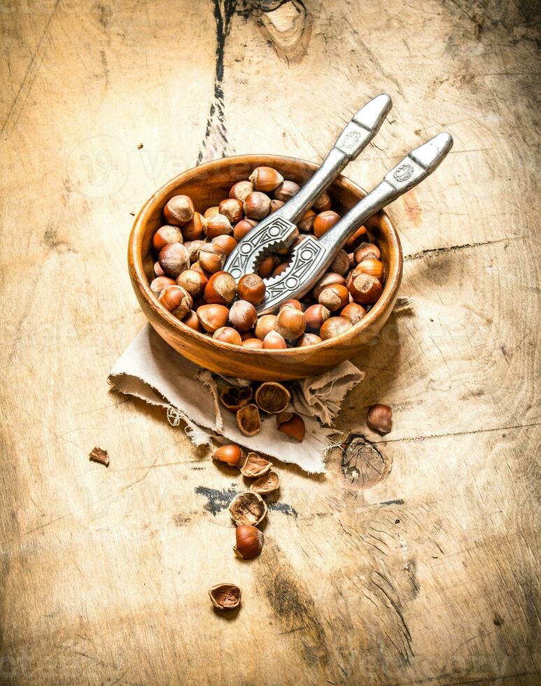 Nuts with Nutcracker in a bowl . photo