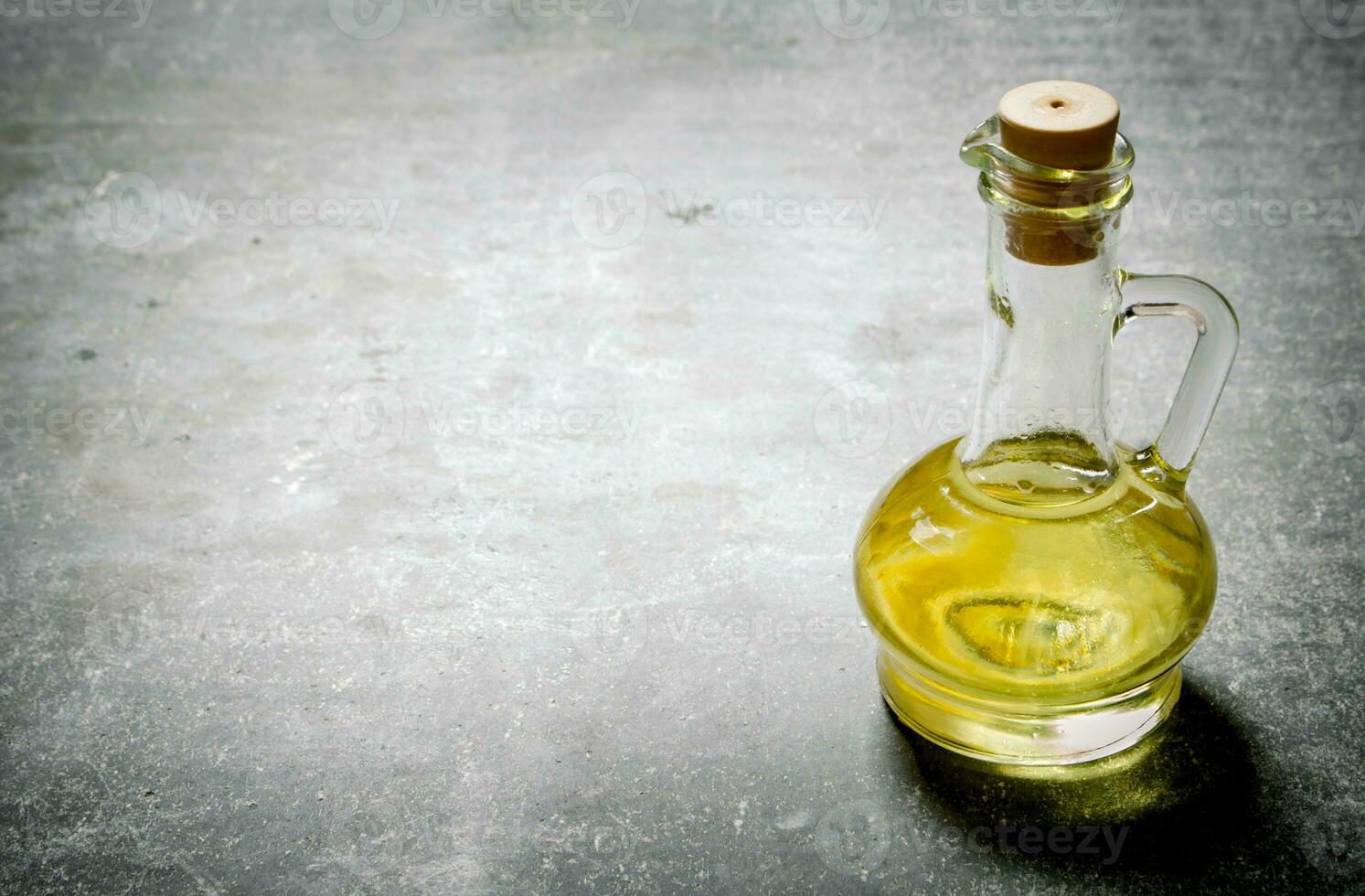 Olive oil in a jug. On stone background. photo