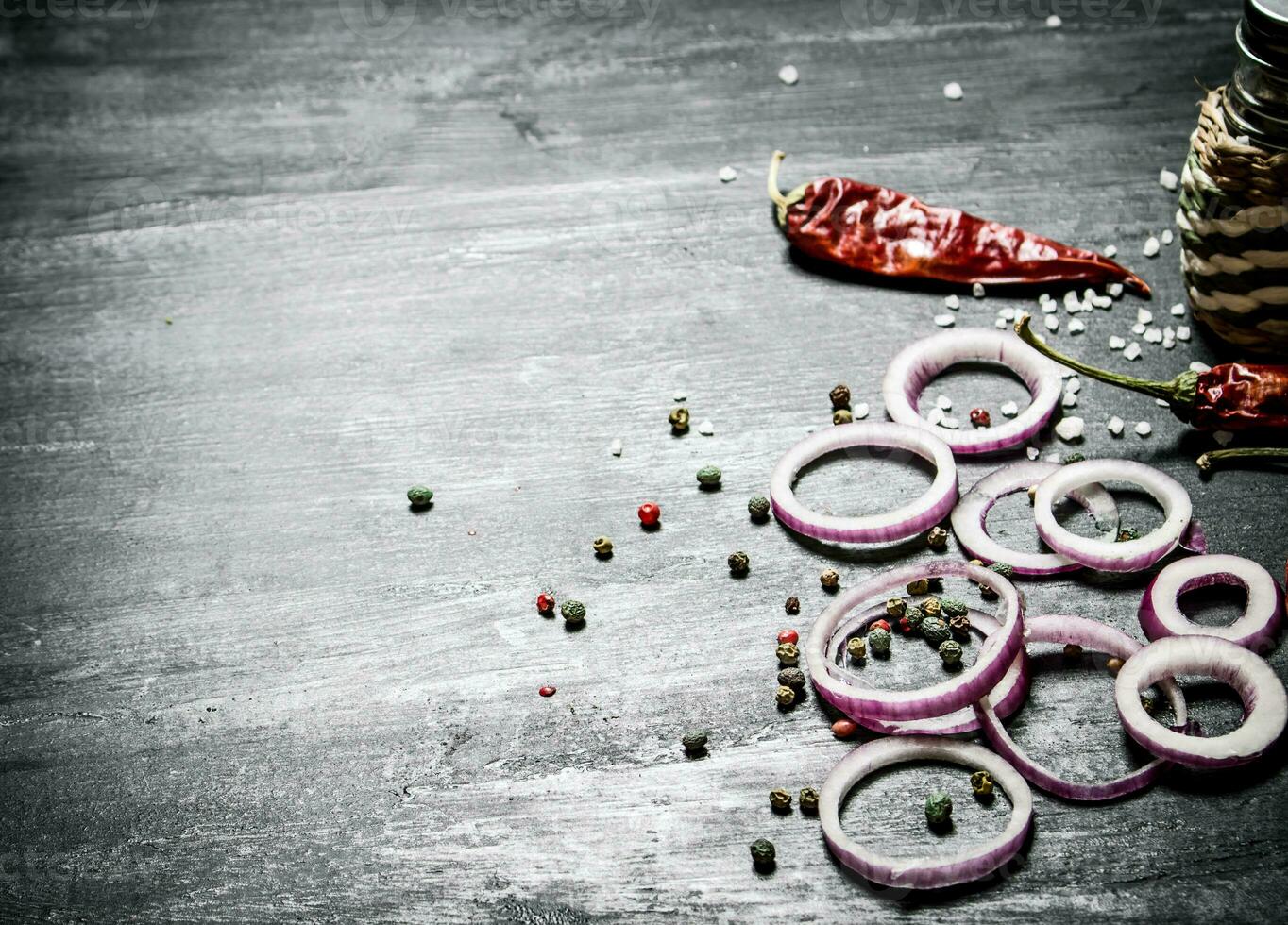 Onion rings and spices. On black rustic background. photo