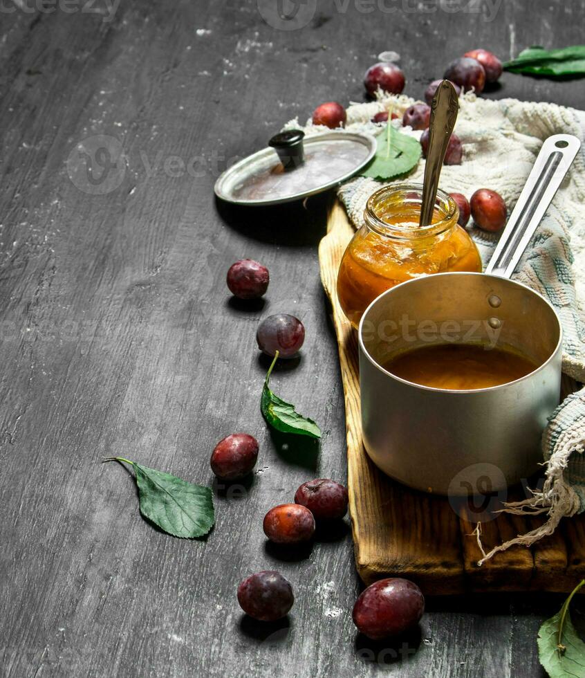 Mashed ripe plums in a small saucepan. photo