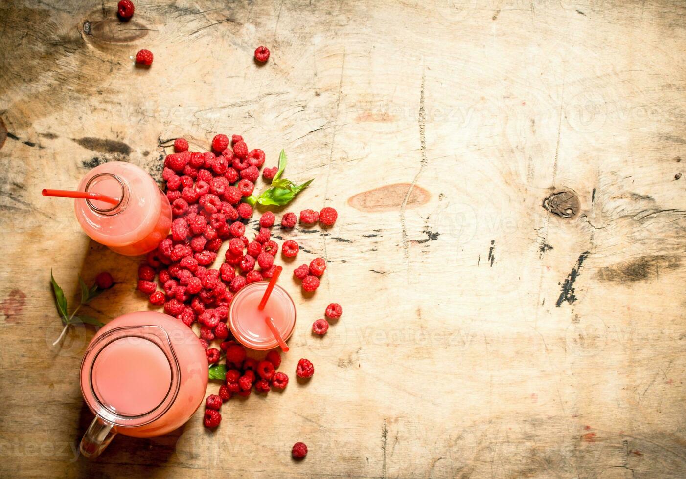 Raspberry juice in the pitcher and glasses. photo