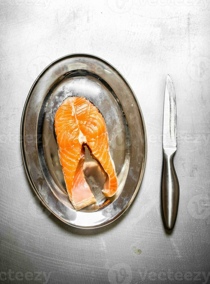 piece of raw salmon on a tray. photo