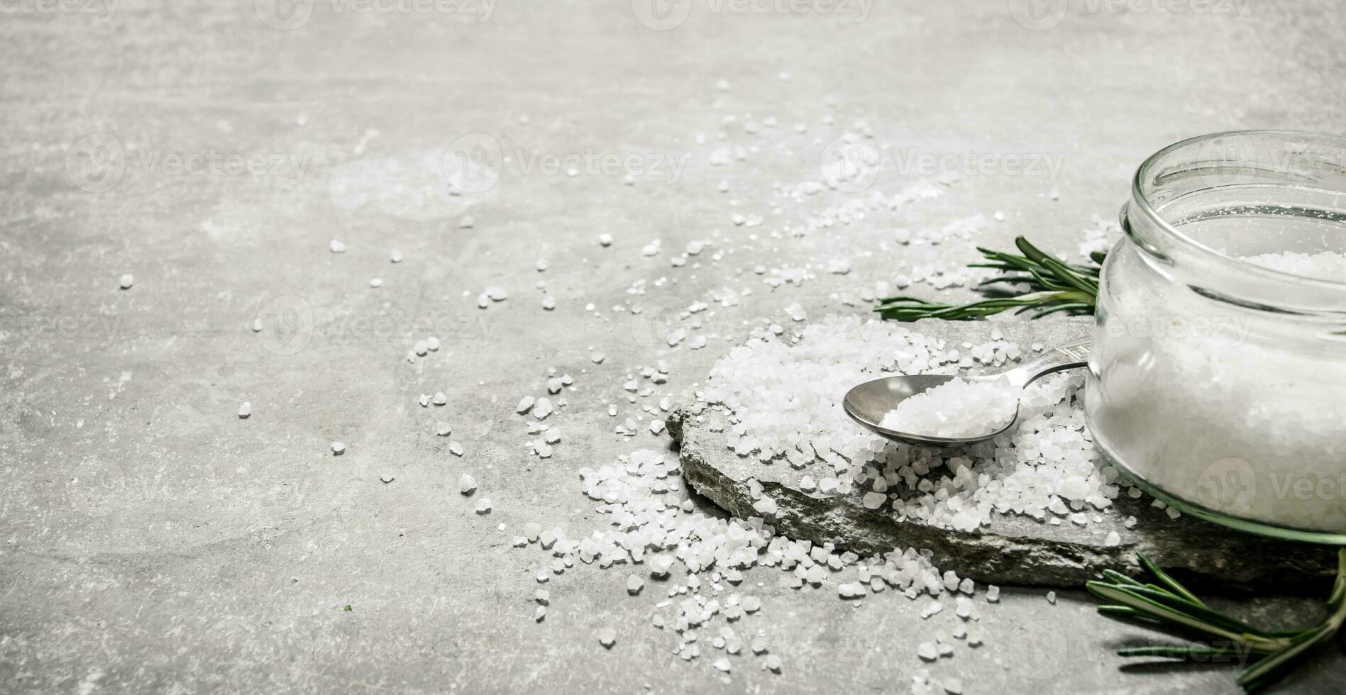 Salt and rosemary. On stone background. photo