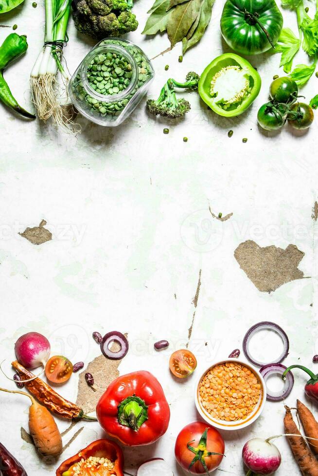 Raw vegetables cut into slices with lentils and green peas. photo