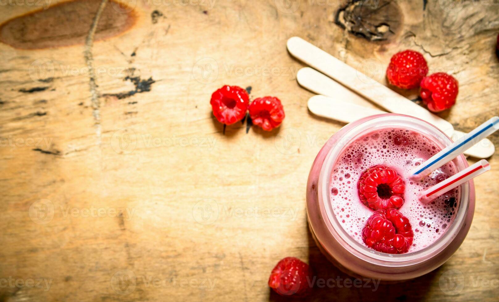 Berry smoothie raspberry with wooden sticks. photo