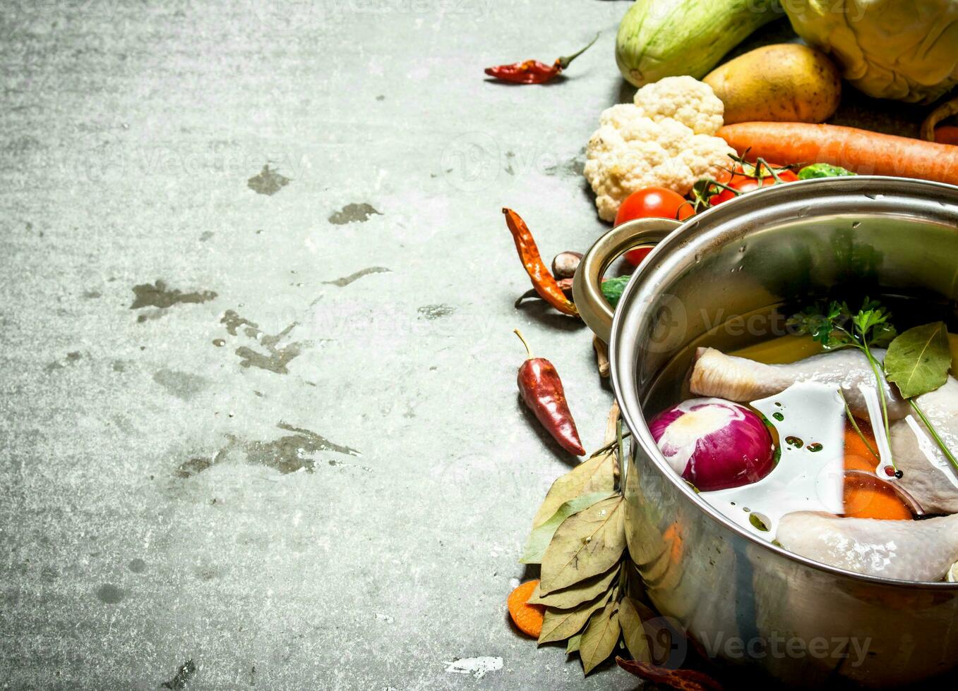 Cooking chicken soup with vegetables in a large pot. photo