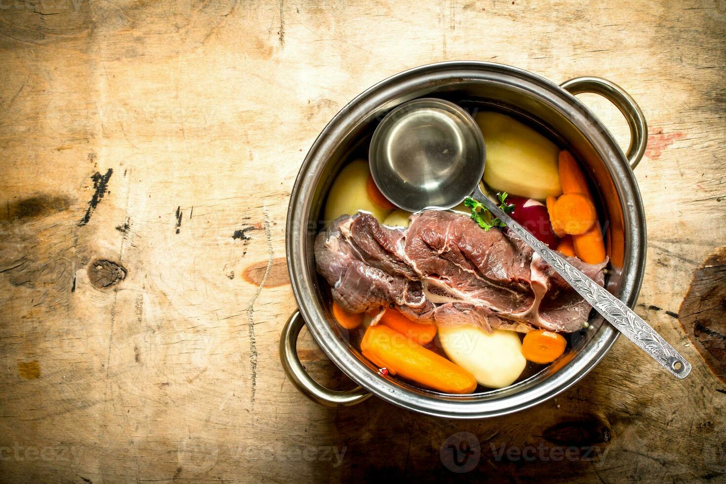 big pot of soup with beef and fresh vegetables. photo