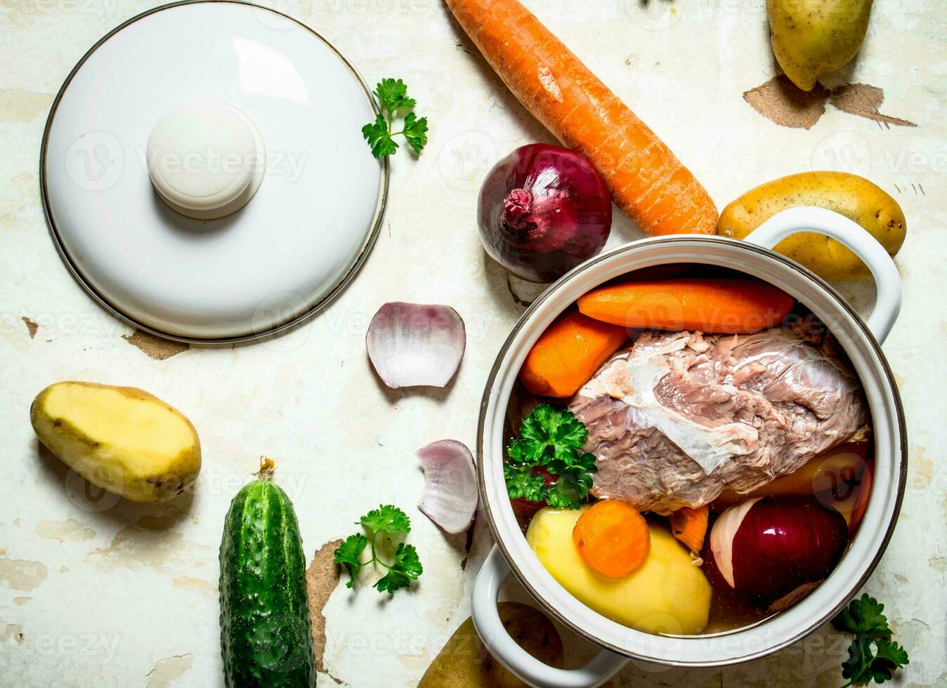 Soup with vegetables, pork, spices and herbs in a saucepan. photo