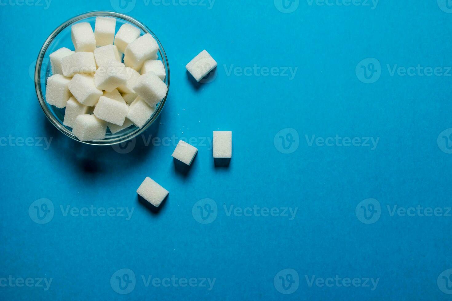 Refined sugar in the Cup. On blue table. photo