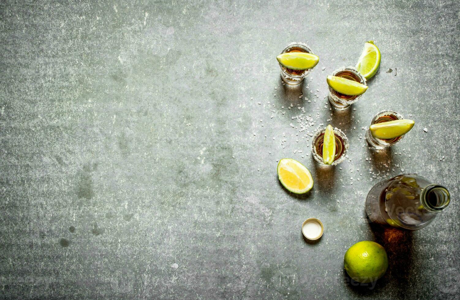 bottle of tequila with lime and salt. photo