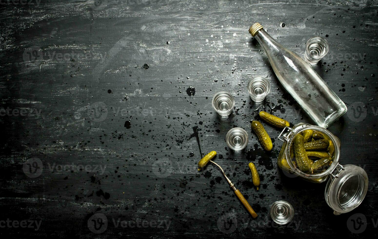 Russian style. Bottle vodka with shot glasses and pickled cucumbers . photo