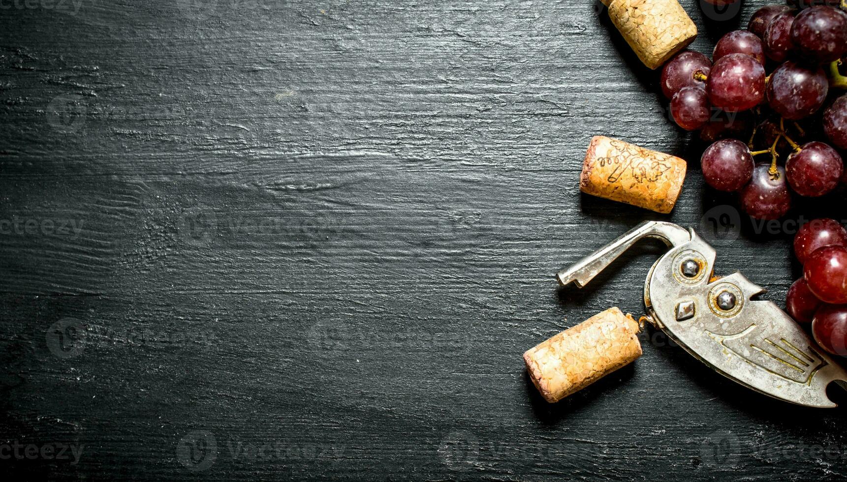 Wine corks with corkscrew and grape branch. photo