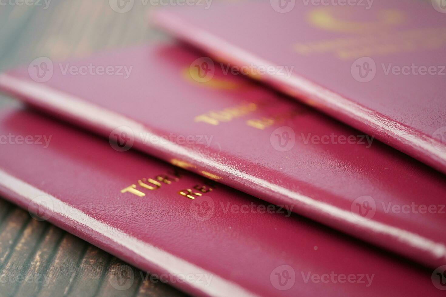 stack of red color passport on table photo