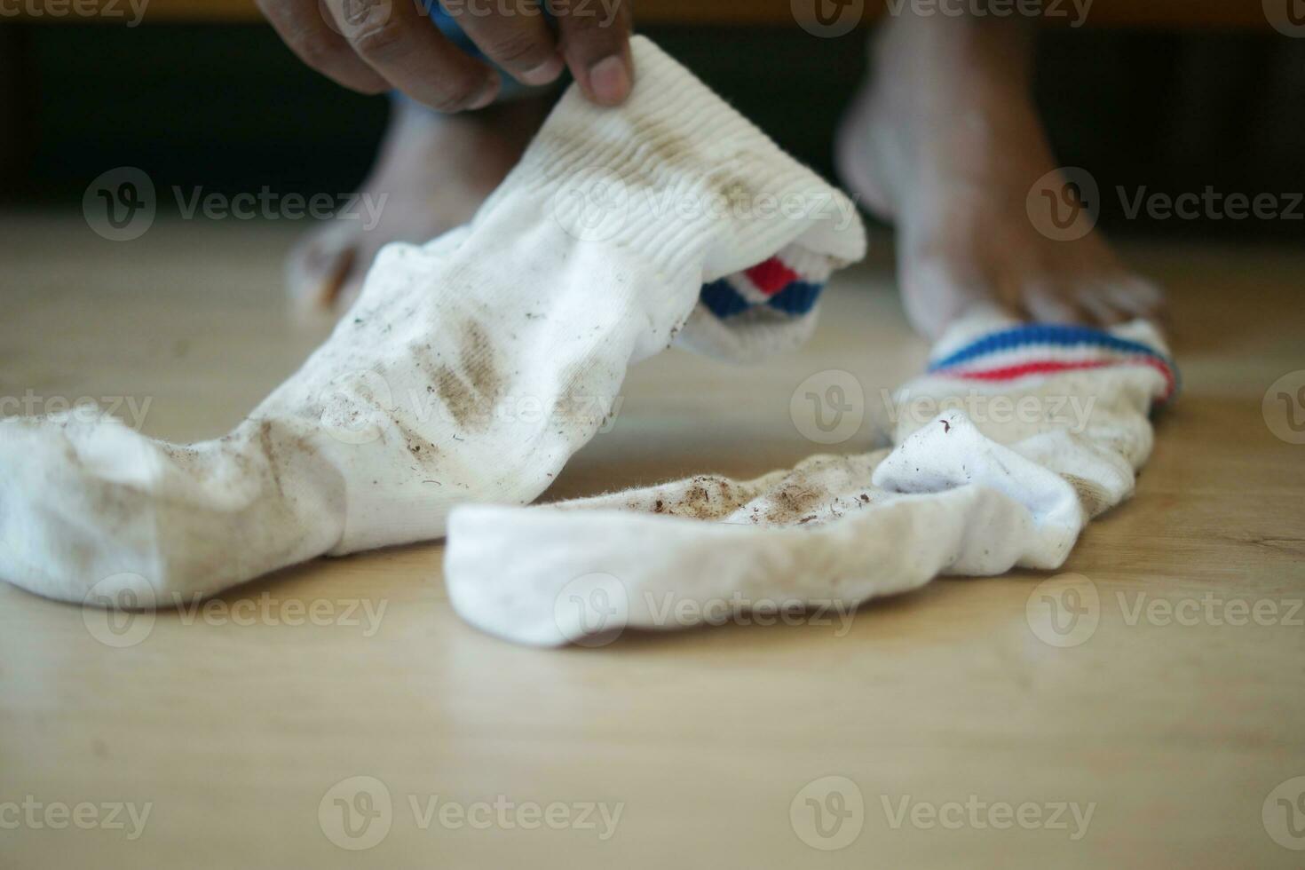 men feet with dirty socks while sitting on sofa photo