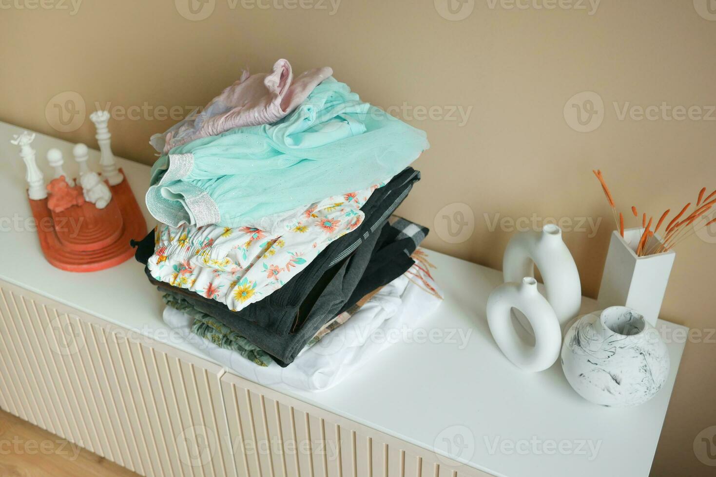 Stack of clothes on table indoor. photo
