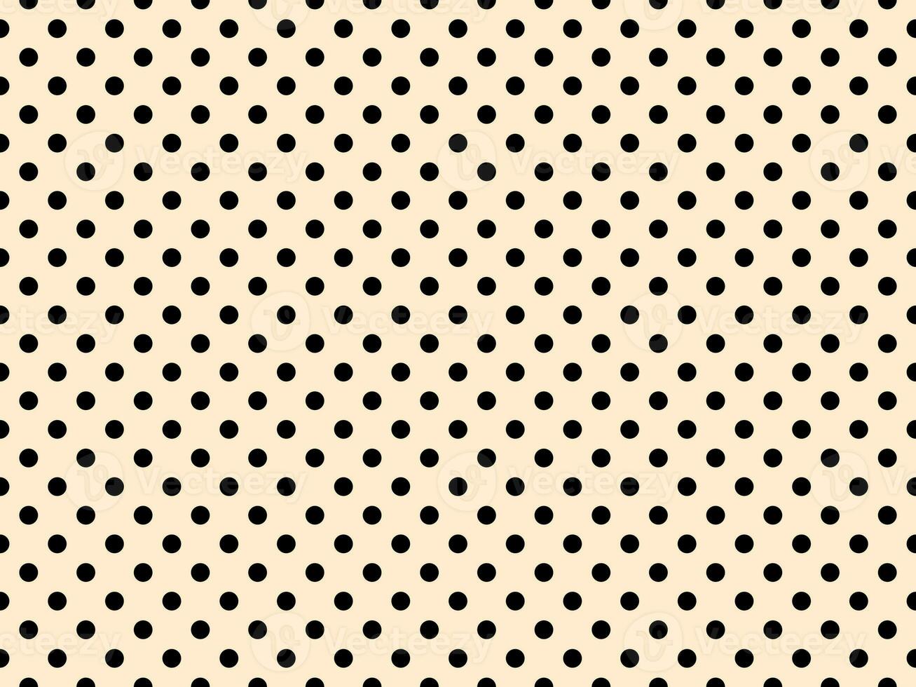 black polka dots over blanched almond background photo