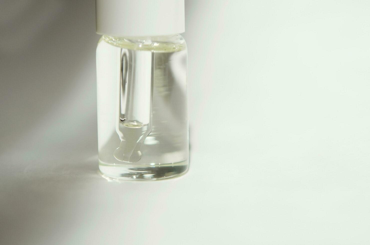 Cosmetic or medical glass bottle with pipette on white background. Skin care concept. Natural hard light, deep shadows. - Image photo