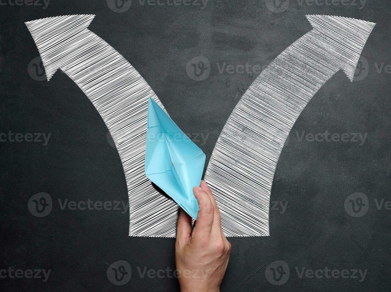 Hand holding a blue paper boat, concept of finding solutions, choosing direction of movement photo