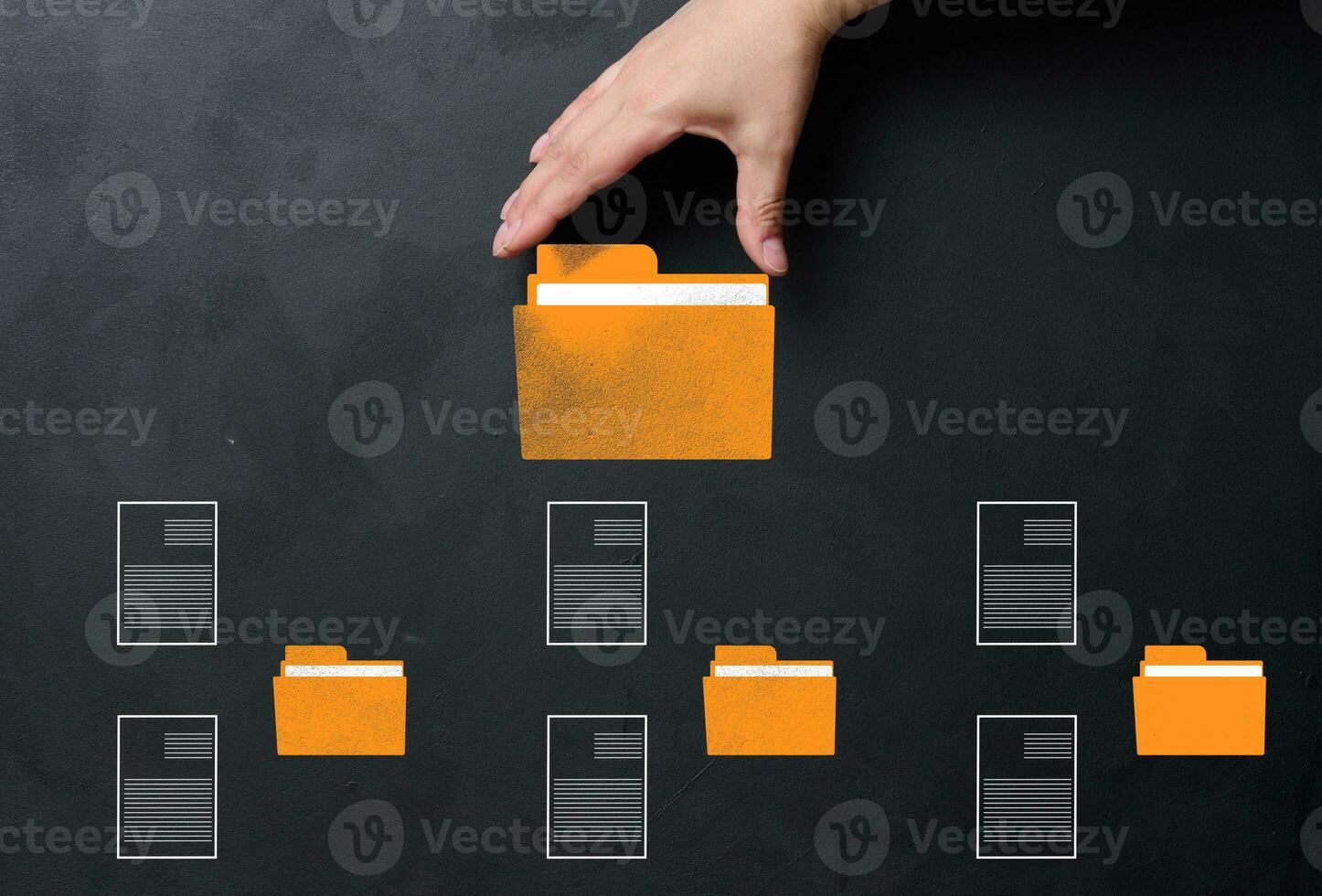 A hand holds a yellow folder over a black background with several folders and documents scattered around. Concept of control and systematization of documents photo