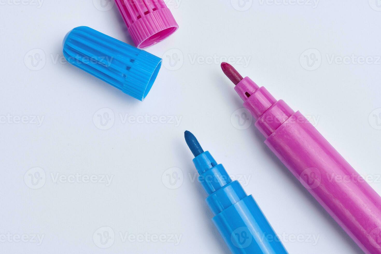 Pink and blue felt-tip pens on white background, top view photo